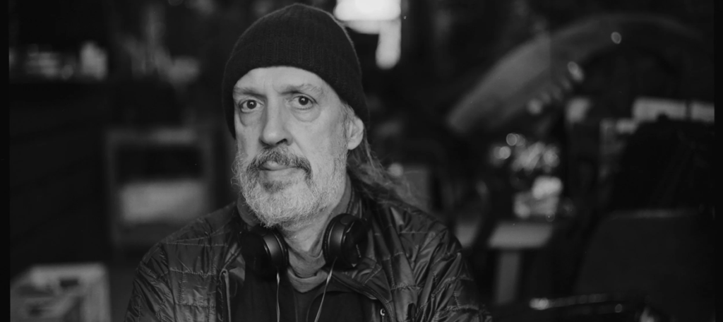 Sometimes the Beat Can Get in the Way of the Rhythm: A Conversation with Kent Jones on Late Fame Kent Jones wearing a beanie and headphones around his neck in a black and white headshot.