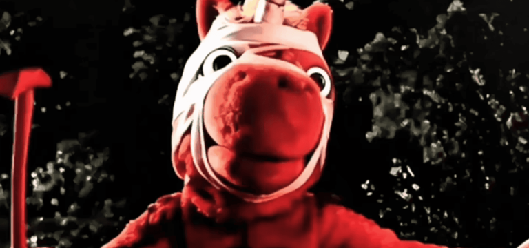 I Hope Nobody Remembers Barney, But Everybody Will Remember Buddy: An Interview with Devon Hakes Ludlow on Buddy Red horse mascot with wide eyes and a white head bandage stands against a dark, leafy background.