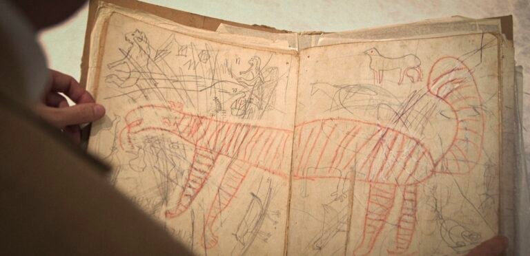 NYFF 2026 — Dispatch 1: Paper Tiger, The Man I Love, The Life of Jorge Luis Borges Hands hold open a weathered sketchbook with a large red striped tiger drawing and pencil sketches.